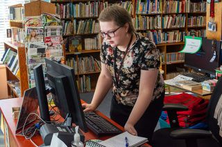 Emily Bonsant/News-Register##Sarah Moldovan, the new Youth Services Librarian at the Amity Library, scans returned books. In her new position, she will oversee the annual summer reading program, which includes crafts, performances and book tracking. This year&rsquo;s theme is &ldquo;Plant a seed, read.&rdquo;