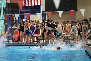 Rachel Thompson/News-Register##The Grizzly swim team pulls co-Head Coach Murilo Martins into the pool at the McMinnville Aquatic Center on Saturday, Feb. 14, in celebration of their total team victory as hosts of the Pacific Conference district meet.