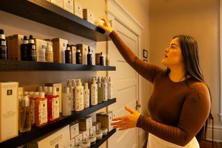 Rachel Thompson/News-Register##Bella Elmer, co-owner of the new Velour Medical Spa on Third Street in McMinnville, reaches for an Eminence Organic Skin Care product on display. Elmer, a certified advanced aesthetician, uses the organic skincare line in the treatments she offers at the spa she opened with her husband, Grayson Elmer.