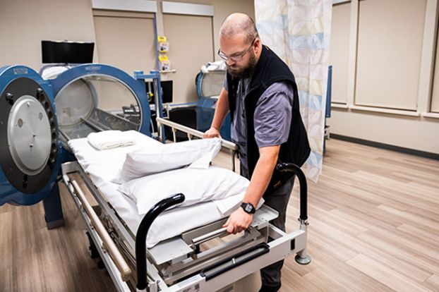 Rusty Rae/News-Register##Safety director Bryce Green pulls a gurney out of a hyperbaric chamber at Willamette Valley Medical Center&rsquo;s wound care clinic. The chamber provides a pure-oxygen environment that promotes healing.