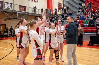 Rusty Rae/News-Register##McMinnville&rsquo;s varsity girls gather around Sean Coste with a round of applause as he is honored for reaching 500 career wins prior to the Grizzlies game against Century on Tuesday, Feb. 24. Coste commended his players as the main reason for his tenured success.
