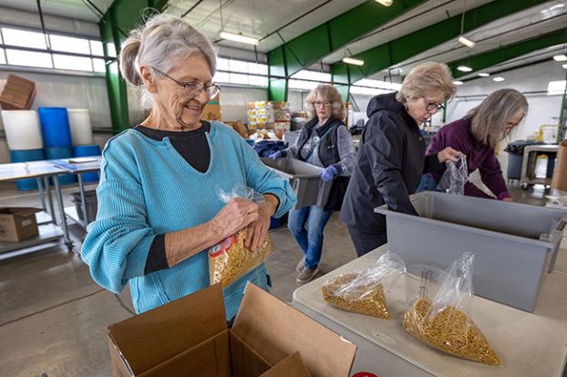 Rachel Thompson/News-Register##McMinnville Garden Club members Judy Toliver, foreground, and background from left, Lisa Binner, Sharon Reed and Linda Velebir help repackage and label pasta and marinara sauce at the Yamhill Community Action Program food bank. YCAP Director Laverne Pitts said the food program stretches its money by buying some items in bulk. Local businesses and organizations, such as the garden club, help divide the big bags into smaller ones for distribution.