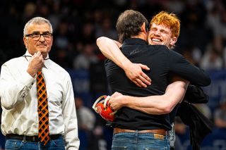 Rusty Rae/News-Register##Adonijah Stanton emphatically embraces Willamina Head Coach Ariah Fasana after winning the 132-pound title.