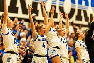 Rachel Thompson/News-Register##The Warriors&rsquo; bench put three&rsquo;s in the air following a make from the arc by Maci King, which put a pin in Amity&rsquo;s playoff win over Western Christian on Feb. 28.