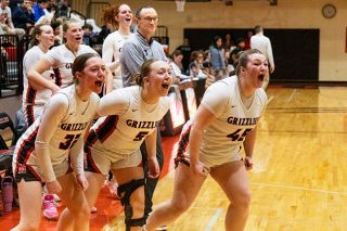 Nathan Ecker/News-Register##Mabel Findley, Alex Bates and Ruby Riddle charge off the bench with passion while celebrating a tough made layup by freshman Grace Carlson during Mac&rsquo;s home win over Liberty on Feb. 26.