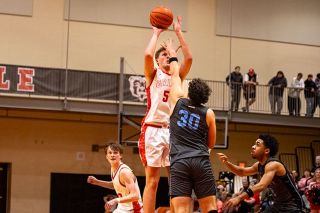 Nathan Ecker/News-Register##Xander Gurash shoots a mid-range jump shot with the hand of Liberty&rsquo;s Brody Brisson in his face during their senior night win on Feb. 26.