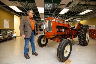 Rachel Thompson/News-Register##Wade Miller, who grew up using Allis-Chalmers tractors and helping sell them in his family&rsquo;s farm equipment business, shows a D-19 model from the early 1960s on display in the Yamhill County History Museum.