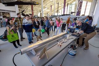 Rachel Thompson/News-Register##Volunteer William Mackie demonstrates a Rubens tube, using propane flames along a perforated metal tube to show how sound waves create visible patterns of vibration. ScienceFest 26, held Saturday at Evergreen Aviation & Space Museum, featured family-friendly demonstrations and activities.