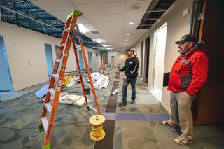Rachel Thompson/News-Register##Project Manager Taylor Haworth, accompanied by Deputy County Administrator Kevin Perkins, right, describes how the Yamhill County Board of Commissioners offices will look when completed. The doorways lead to future offices for commissioners and county administrative staff, and ladders will be replaced by cubicles for support staff.