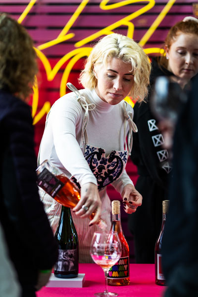 Rachel Thompson/News-Register##Anna Sweet, founder of Artist Block Wine in Dundee, pours a taste of &ldquo;Yummy Yummy Yummy,&rdquo; a grape skin-contact Pinot Gris, for guests at her booth.