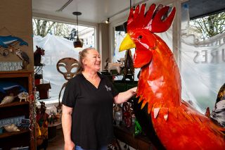 Rusty Rae/News-Register##Kristi Bahr checks out Brutus the rooster, one of many gift items available at Uncorked Treasures, which opens Saturday, March 21, at 300 N.E. Third St. The shop has gifts on one side and a wine bar with both local and other wines on the other. Bahr, whose parents ran Found Objects, is partners in Uncorked Treasures with Krista Gallentine. Family members on both sides have helped start the business.