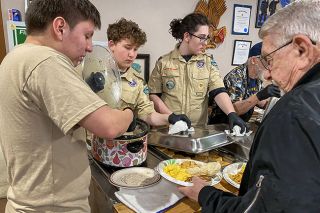 Starla Pointer/News-Register##Jose Duenas, left, of the Sea Cadets dishes up gravy as Boy Scout Dexter Miller, second from left, serves biscuits to Gary Miller, right, during the Navy and Coast Guard breakfast Sunday.