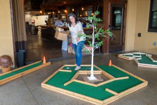 Rusty Rae/News-Register##Serendipity owner Becky Simpson decorates an Easter egg tree that marks one of the holes at the Sweet Spot miniature golf pop-up in the 1882 buildings on Galloway Street between Third and Fourth in downtown McMinnville. The course, decorated with oversized ice cream cones and sweet treats, opens at 4 p.m. today and continues daily through March 29 as something for families to do during spring break. In addition to mini golf, the attraction offers ice cream, loaded popcorn and other treats for purchase.