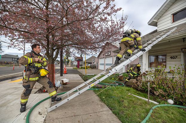 Rachel Thompson/News-Register##Grand Ronde firefighters Micah Brown and Brock Rogers move into position for a second-story entry during a search-and-rescue training exercise Tuesday, March 17, at 407 Trade Street in Amity, a city-owned house slated for demolition.