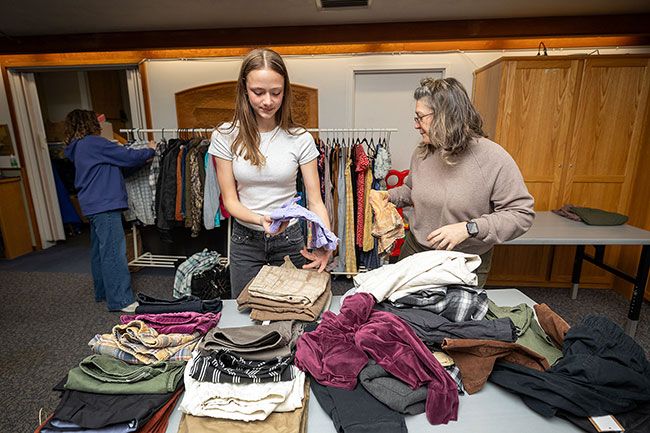 Rachel Thompson/News-Register##Hannah Malstrom, a Patton eighth-grade leadership student, helps lay out used clothing along with school social worker Megan Cornelius prior to the pop-up thrift shop Tuesday. Hannah said PMS leadership students thought a clothing swap would be helpful for middle schoolers, then found out that the library and Duniway Middle School students were making plans along the same lines.