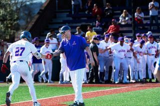 Rusty Rae/News-Register##The Wildcats crowd home plate at Roy Helser Field to greet Kennel, who shakes hands with a grinning Bryn Card, following his walk-off homer. They carried the momentum into a game two victory in what was a doubleheader game day.