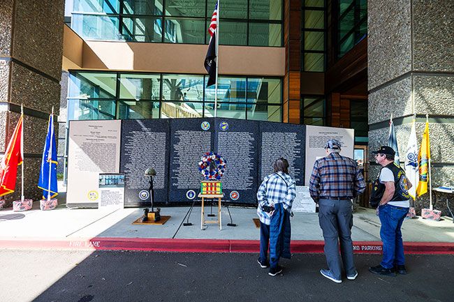 Rachel Thompson/News-Register##Susan and David Vandewater of Chehalis, Washington, view the Oregon Memorial Traveling Wall alongside Vietnam veteran Tom Beckley, right, on Friday at the Evergreen Aviation & Space Museum in McMinnville. The wall, a project of Vietnam Veterans of America Chapter 805 in Roseburg and the Umpqua Valley, lists the names of Oregon service members who died in the Vietnam War and honors those lost in later conflicts. American Legion Post 21 of McMinnville brought the wall to Evergreen March 27-29; it travels to communities across the state.