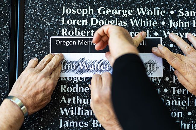 Rachel Thompson/News-Register##Vietnam veterans Terry Weakley, left, and Tom Davis make a name rubbing of Jon Walter Layton III of McMinnville. A first lieutenant in the U.S. Army Special Forces, Layton was killed in Vietnam on June 27, 1968, at age 20. In honor of the service members listed on the wall, American Legion members and local Boy Scouts stood guard at the wall over the weekend.