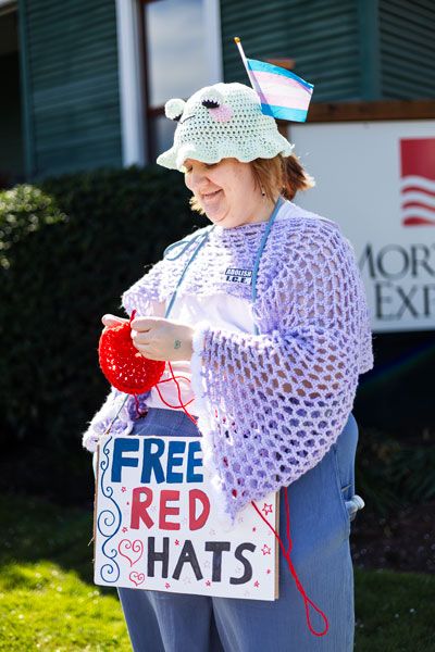 Rachel Thompson/News-Register##Benny Johnson of Newberg crochets red resistance hats to give away to Block Party participants. The hats are inspired by the Norwegian nisselue, worn as a symbol of resistance during World War II, and have been reinterpreted in recent anti-ICE protests in Minnesota.