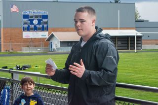 Ossie Bladine/News-Register##Amity senior Jaxson Howard recaps the day of events with participants and their parents of the Throw for a Cure track and field clinic and mock meet on Sunday, March 29, at Amity High School. Howard organized the event to raise money for Type 1 diabetes research. The Warrior athlete was diagnosed with the condition his sophomore year.