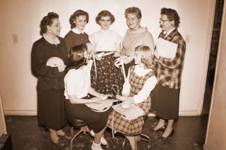 ## (April 3, 1956) Sale of scrip will determine which of these girls will reign as queen of the 4-H Carnival April 13. The candidates receive rolls of the scrip from Mrs. Margie Johnson, at left, and Mrs. Naomi Rogers, at right, carnival officials. The girl selling the highest number of tickets will be crowned queen with runners-up serving as members of the royal court. Candidates, each representing different areas of Yamhill County, are, Jeannette Powell, Yamhill and Carlton, seated at left, and Sharon Ericksen, Lafayette and McMinnville. Standing, from the left, are Elaine Rogers, Sheridan and Willamina; Cheryl Stephens, Amity,and Jean Johnson, Dayton and Dundee.