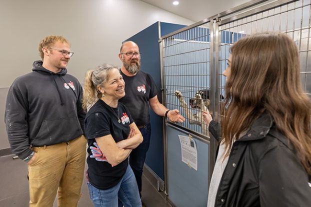 Rachel Thompson/News-Register##Homeward Bound Pets Director Casey Shook, right, introduces Max the adoptable dog to, from left, Max, June and Eric Wolff of Worx Construction in the kennel at HB Pets&rsquo; new headquarters on Loop Road, east of McMinnville. Worx has been building the shelter for both dogs and cats, with offices for people, over the past year. Dogs are moving in, and it will open about June 1.