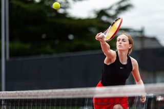 Rachel Thompson/News-Register##McMinnville senior Penelope Hanson reaches across her body to touch an opponents return attempt back across the center line in a doubles match with Sage Kamph on Saturday, April 11, at Cowls Courts. Hanson and Kamph were victorious 6-0, 6-3 in their win over Sandy to help Mac to their sixth team win of the season.