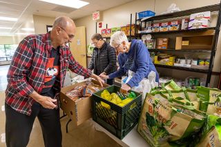 Rachel Thompson/News-Register##Tim and Emily Duerfeldt package food bags for low-income students at Wascher Elementary School, with help from Dana Libonti. The Duerfeldts have received the Linda Lyon Community Service Award from the city of Lafayette.