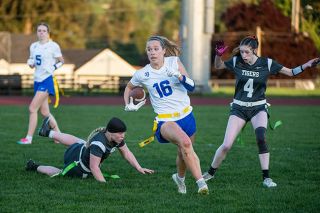 Rusty Rae/News-Register##Adie Nisly runs past a collection of Tiger defenders on her way to a huge chunk of yards, which the Warriors secured with regularity in the first ever flag football competition between Yamhill County rivals.