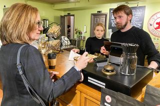 Starla Pointer/News-Register##U.S. Rep. Andrea Salinas, D-Oregon, buys a black vanilla tea from Serengeti Savage and Richard Smith, owners of the Velvet Monkey. She visited the tea shop Thursday during a stop in downtown McMinnville to talk with owners of small businesses. Smith and Savage told her how tariffs have raised their costs and made it harder to import supplies; owners of Entwined yarn shop and Hopscotch Toys had similar stories.