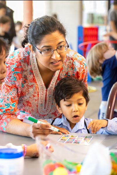 Rachel Thompson/News-Register##Sahaan Solanky, 3, reacts to a call as he plays Loter&iacute;a with his aunt, Snahal Hermens. The traditional Mexican game, similar to bingo, was among the activities offered for children and families during D&iacute;a de los Ni&ntilde;os. The free event, also known as Children&rsquo;s Day, celebrated youths and a love of reading with storytime and drop-in activities including games, crafts, snacks and giveaways.