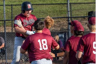 Nathan Ecker/News-Register##Dayton freshman Owen Clark jumps into the embrace of his teammates (Brody Douthit and 	Mason Perez, 18) while celebrating his first varsity home run, a two-run shot well past the 320 marker on Yamhill Carlton&rsquo;s left field wall. Clark pumped his fists and shouted all the way around the bases with what was the deciding swing in the Pirates&rsquo; 9-3 win over the Tigers at YCHS on Friday, May 8.