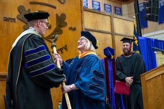 Rusty Rae/News-Register##Julie Fitzwater, a 2006 Linfield graduate who&rsquo;s now a nursing professor and chair of the Faculty Senate, presents the university&rsquo;s mace to new president Mark Blegen during his inauguration ceremony Friday. The ceremonial mace represents the authority of the faculty and the faculty and president&rsquo;s shared responsibility for educating students, Fitzwater said.