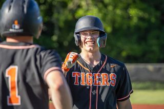 Nathan Ecker/News-Register##Yamhill Carlton senior Jason Kelley cracks a wide smile while preparing to share a fist bump with Porter Carden after reaching first base and being pinch run by the latter. Kelley drove in one run and was a happy camper, along with the rest of his squad, in the Tigers&rsquo; 11-5 win over Dayton on Monday, May 11 in Dayton.