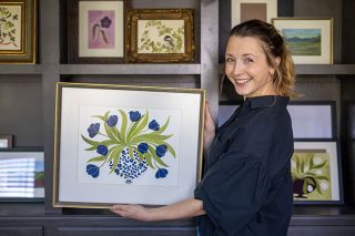 Rachel Thompson/News-Register##Amity area artist Anna Flores shows her paintings, including one with blue tulips nodding over a vase itself made of blue flowers. Painting brings her comfort and lets her depict the beauty around her, she said, adding that the tulip design is &ldquo;what my heart wanted&rdquo; on the day she painted it.