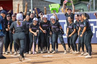 Nathan Ecker/News-Register##The Wildcats crowd around home plate to greet Ashlyn Aven with a celebration chain and raucous yells after her 23rd home run of the season in Linfield&rsquo;s regional championship victory over Transylvania University on Saturday, May 16, at Del Smith Stadium. It was her third in three regional tournament games.