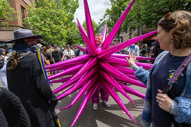 Rachel Thompson/News-Register##Marty Beckers of Las Vegas draws curious looks with his bright pink spiked costume while making his way down Third Street.