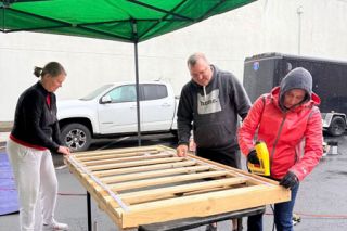 Submitted photo##Wendy Autencio Brooker, right, fastens a bed frame together as she works with her husband, Chris Brooker, center, and Jamie Queener, left, who started Sleep in Heavenly Peace&rsquo;s McMinnville group with her husband, Dave Queener. All are on the board of the nonprofit organization that makes beds for children. They and other volunteers will be building more beds from 9 to noon Sunday, May 31, at the Yamhill County Fairgrounds. Community members are welcome to help.
