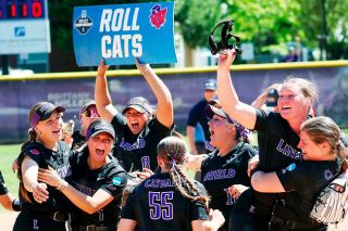 Photo courtesy of Kelly Bird, Linfield Athletics##Wildcats&rsquo; senior catcher Ashlyn Aven holds up her pitcher, junior Tyler McNeley, as Linfield celebrates its trip to the NCAA College World Series with a victory over Moravian University on Friday, May 22, at Del Smith Stadium.