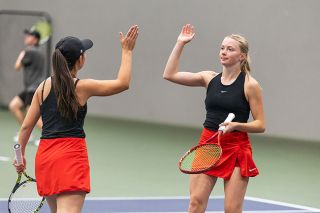 Nathan Ecker/News-Register file photo##Madeleine Hendricks and Caroline Rickards high five after winning a point in their Pacific Conference winning match on Friday, May 15, at the Linfield Tennis Center.