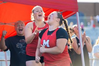 Nathan Ecker/News-Register##McMinnville senior Ruby Riddle rejoices over her record setting hurl of the discus to earn a bid to the state championships. Her teammate and fellow record setter, Brooke Johnston, joined in the excitement along with throwers from other Pacific Conference schools during the district championships on Friday, May 22, at George Fox University&rsquo;s Stoffer Family Stadium.