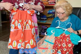 Starla Pointer/News-Register##Shellee Baidenmann of Carlton, left, and her mother-in-law, Jan Baidenmann of McMinnville, discuss garments they&rsquo;ve made recently for Dress a Girl Around the World. They are working on their second batch for the charity, which provides clothing for girls in Africa and other impoverished places.