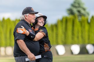 Rachel Thompson/News-Register##Tigers&rsquo; senior Peyton Gregor embraces Head Coach John Kuehnel during a break in the action as YC cemented their lead over Scio in Yamhill for an 11-3 quarterfinal victory on Friday, May 29.
