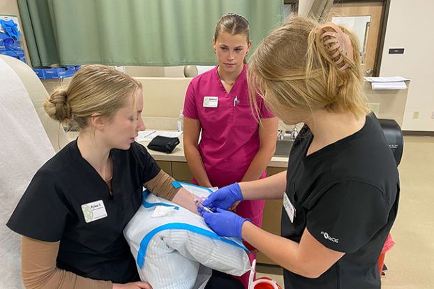 Starla Pointer/News-Register##Kylie Wilson, right, draws blood from fellow medical assisting student Rylee Strong, left, while Mallorie Turley monitors the practice session. All three earned their MA certification through the McMinnville High School/Chemeketa Community College class.