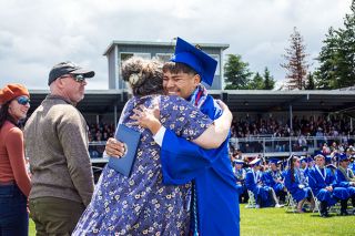 Emily Bonsant/News-Register##Amity High School graduate Emilio Gonzalez hugs commencement speaker and Amity Middle School Principal Mary Matocha after receiving his diploma on Saturday. Matocha taught many members of the Class of 2026 in middle school and reminded the Warriors about how they have persevered.