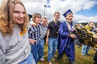 Rachel Thompson/News-Register##Graduate Aiden Molina, right, celebrates with friends Perrin Hanson, Allias Desnoyers, Nolan Boekhoff and James Peterson as classmates and families fill the field following commencement.