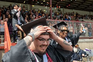 Rusty Rae/News-Register##Alex Hickman, right, pops the lid on a container of confetti as he and Diego Moreno-Tovar descend the stairs from the grandstand at the Dayton High School graduation. Abraham Del Valle is in the background, waiting to go down the steps.