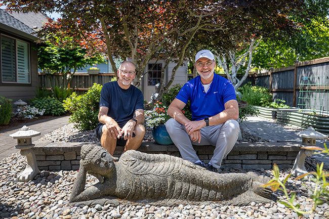 Rachel Thompson/News-Register##Gates, left, and Hall with a reclining statue in one area of their backyard garden. Everywhere you turn in the yard, there&rsquo;s a different vignette, Hall said.