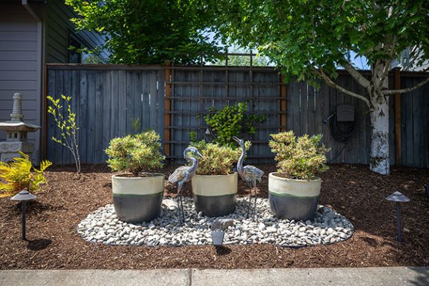 Rachel Thompson/News-Register##Heron statues and potted plants create a focal point in the side garden at the home of Don Gates and Steve Hall of southwest McMinnville. Gates said he loves birds; there are numerous avian sculptures in their expansive yard.