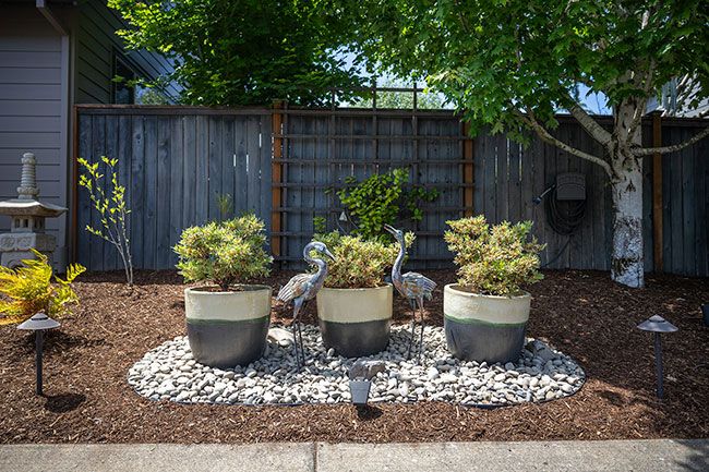 Rachel Thompson/News-Register##Heron statues and potted plants create a focal point in the side garden at the home of Don Gates and Steve Hall of southwest McMinnville. Gates said he loves birds; there are numerous avian sculptures in their expansive yard.